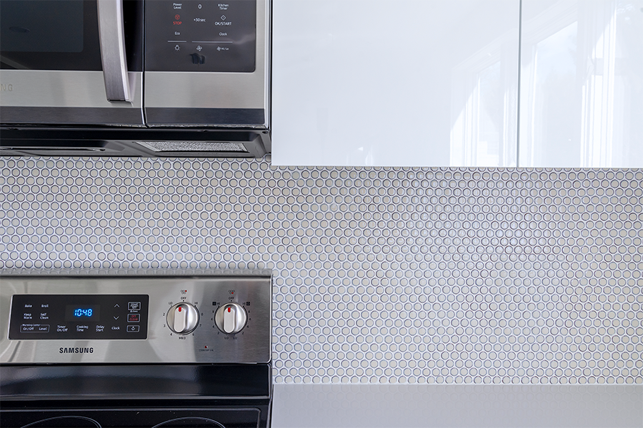 Penny round tile beautifully placed and grouted creating a unique kitchen backsplash.